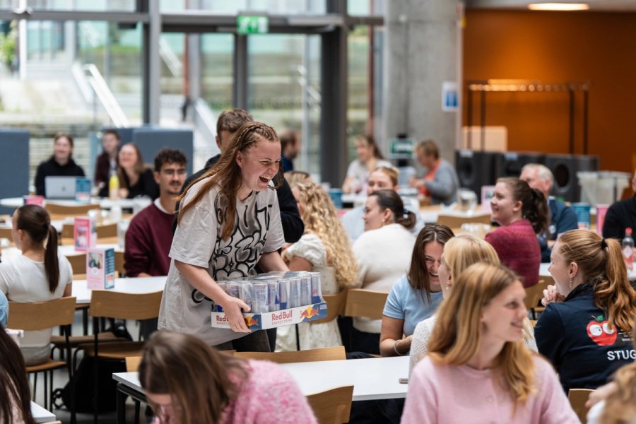 En student ved Kalvskinnet vant et helt brett med redbull og ler og koser seg når hun bærer premien tilbake til bordet.