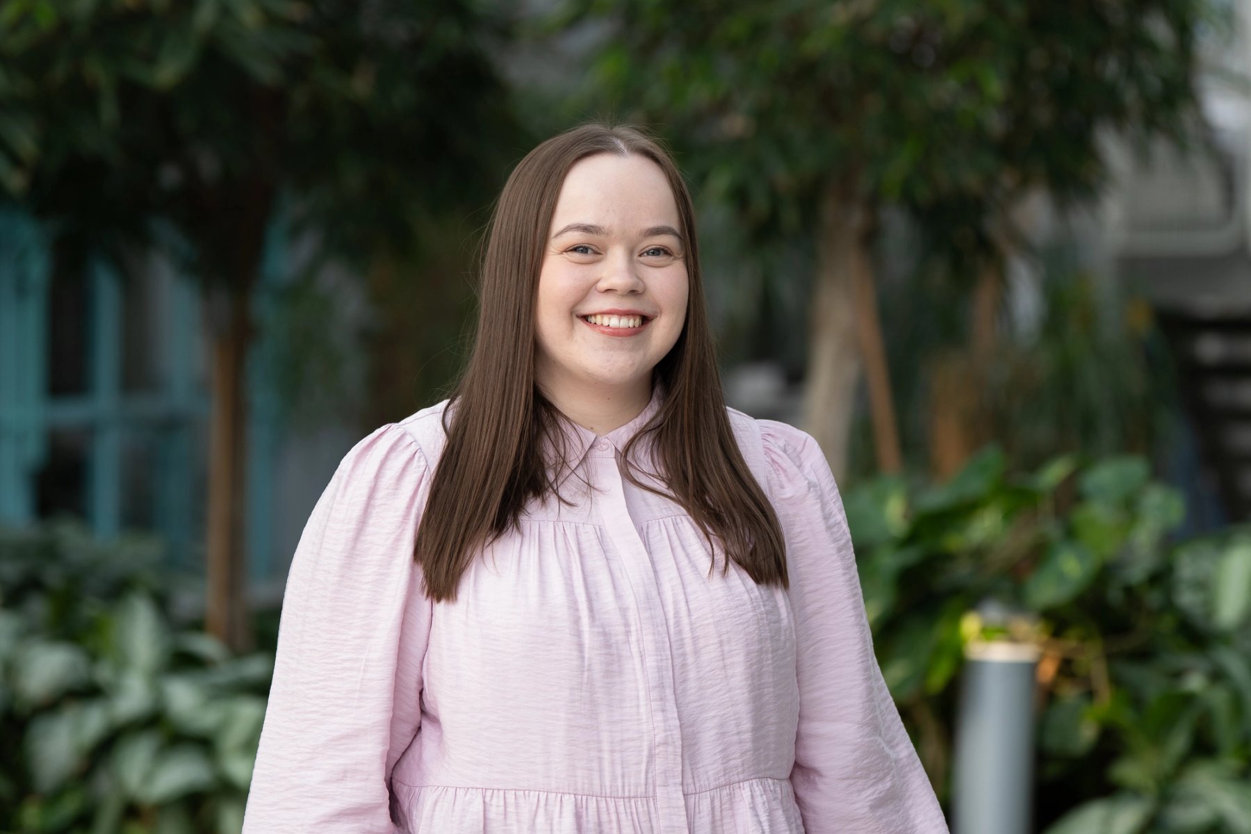 Kamilla Elene Samuelsen, studentvalgt, smiler mot kamera i et grønt utemiljø.