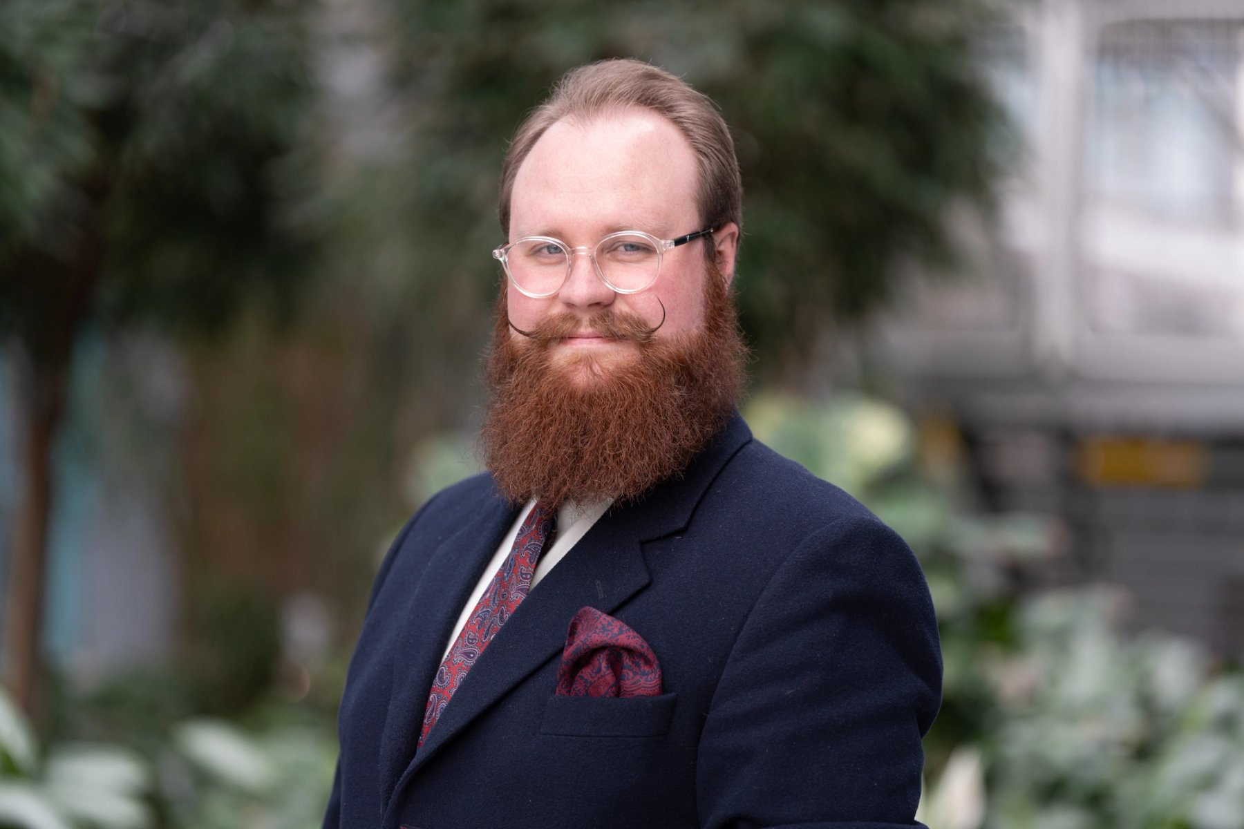 Erik Johansen (Nestleder), studentvalgt, smiler mot kamera i et grønt utemiljø.