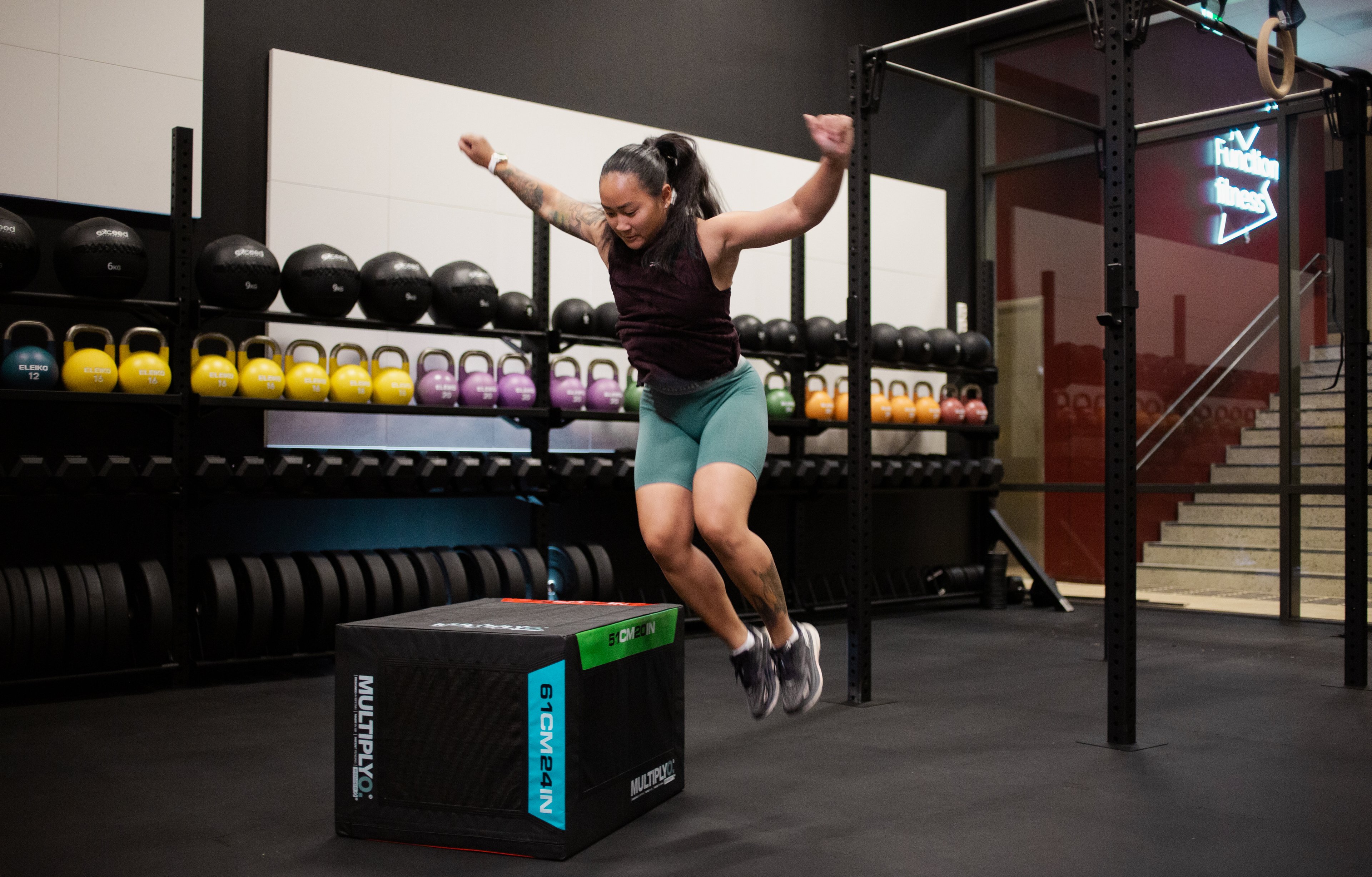 En jente som hopper sidelengs opp på en knehøy kasse.