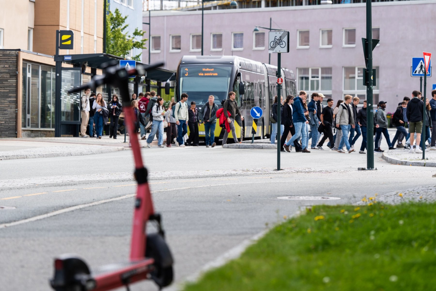 Flere titalls studenter strømmer av bussen på Gløshaugen