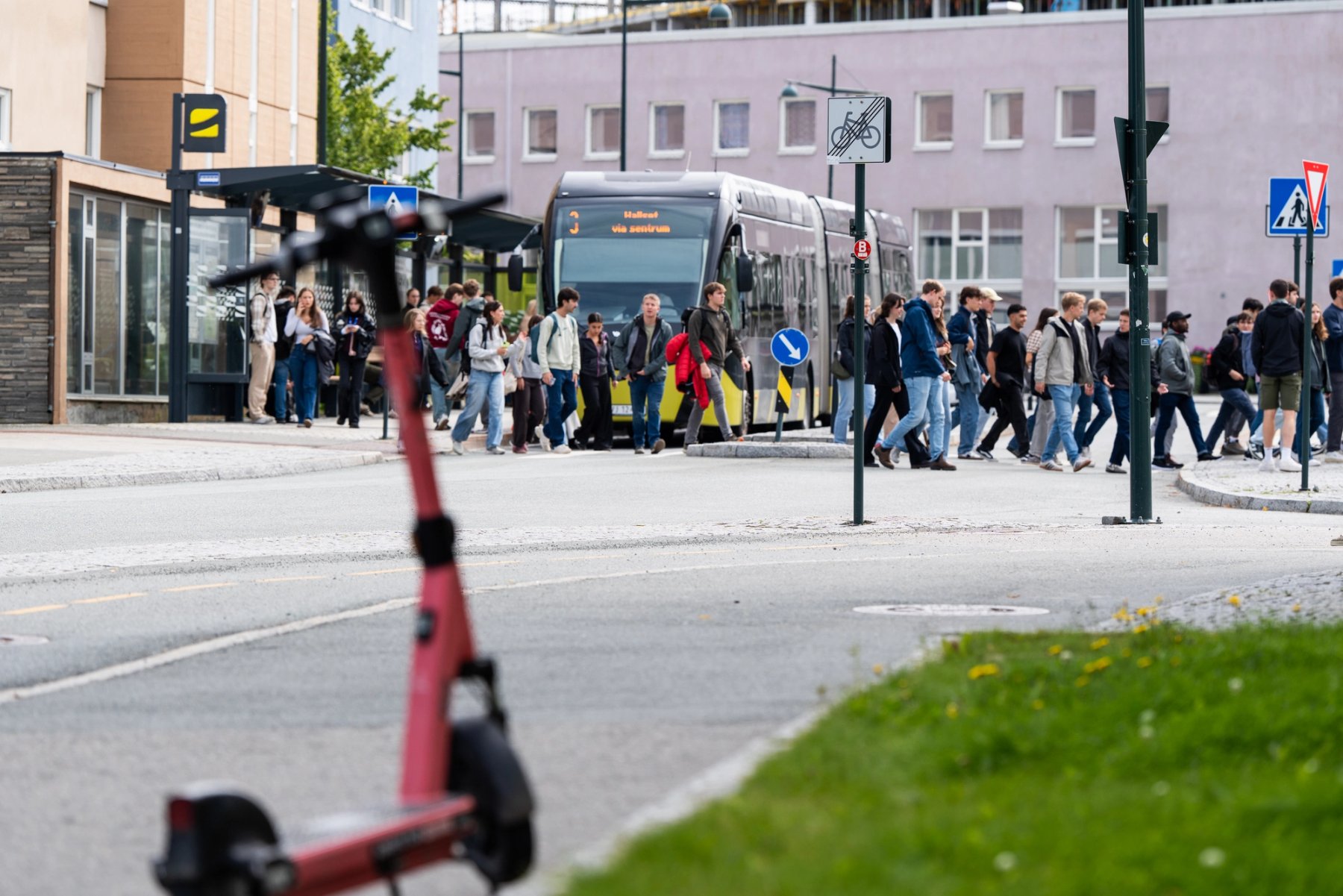 Flere titalls studenter strømmer av bussen på Gløshaugen