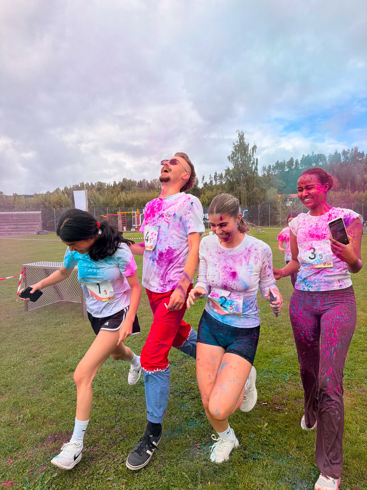 Fire studenter som løper og har fått masse farger på seg på color race