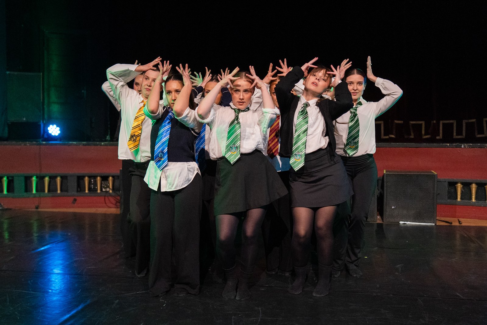 Seks musikere i bandet Quintus sitter på stoler og spiller ulike blåseinstrumenter og tromme, iført mørke skjorter, i et lyst rom.