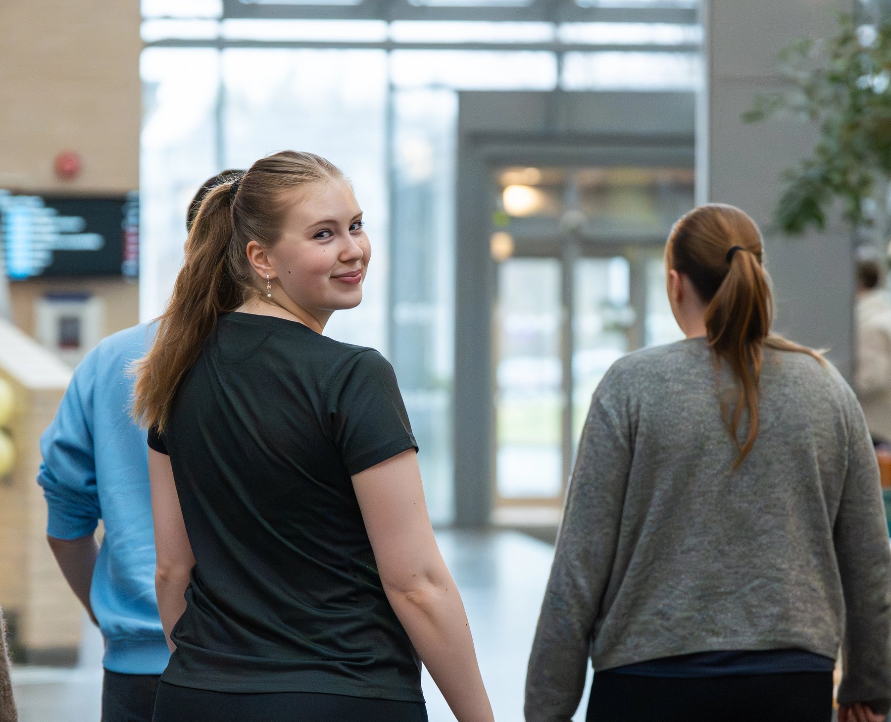 Studenter går sammen gjennom et lyst og åpent innendørsområde i et NTNU-bygg.