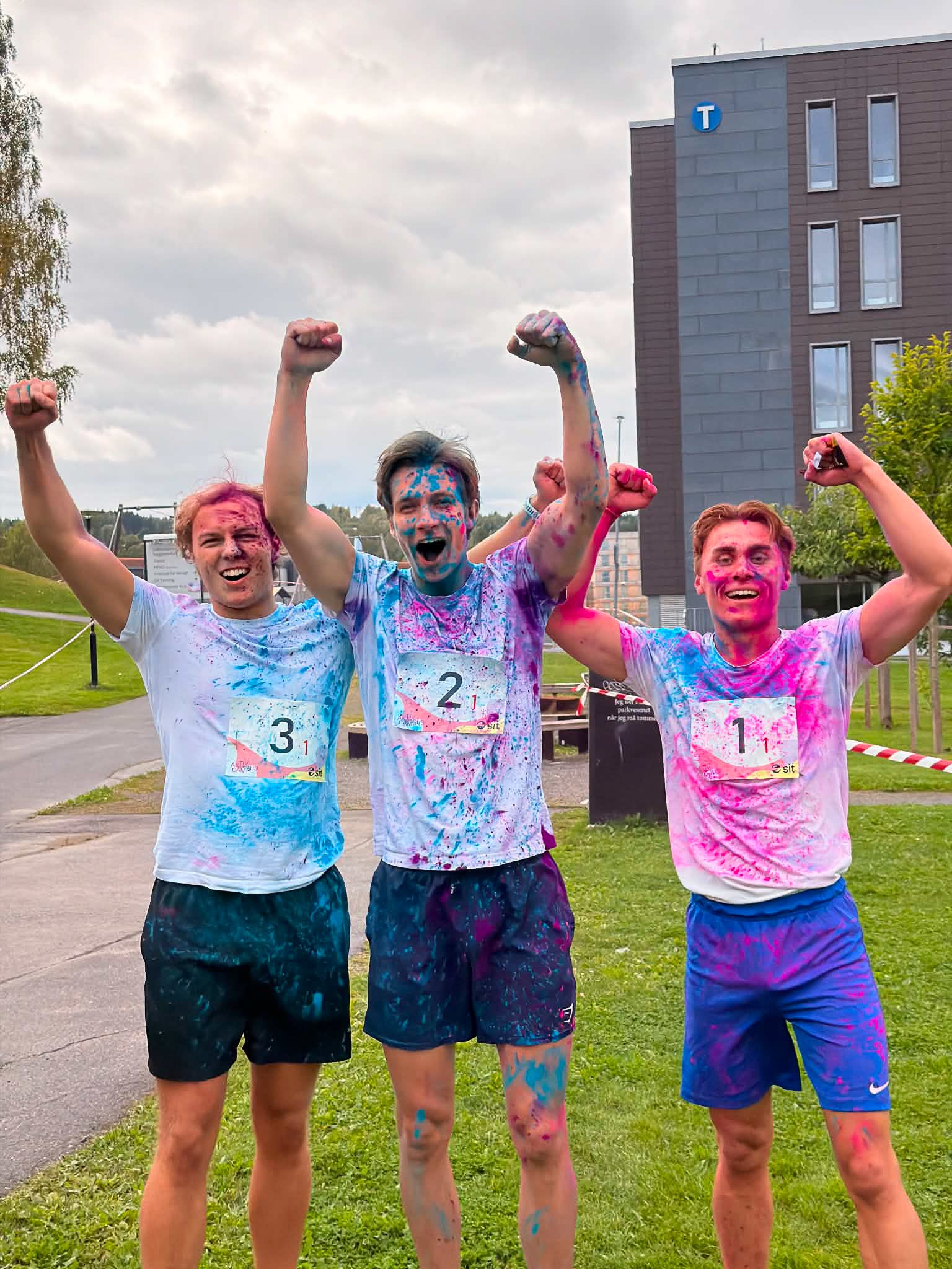 Tre studenter som jubler etter å ha fullført Color Race