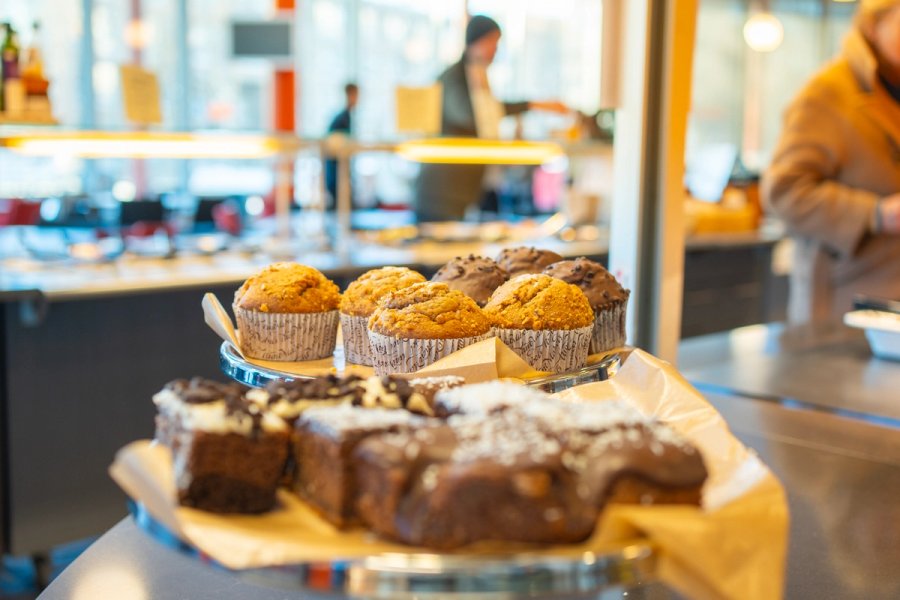 Utvalg av muffins og skolebrød på fat i kantine.