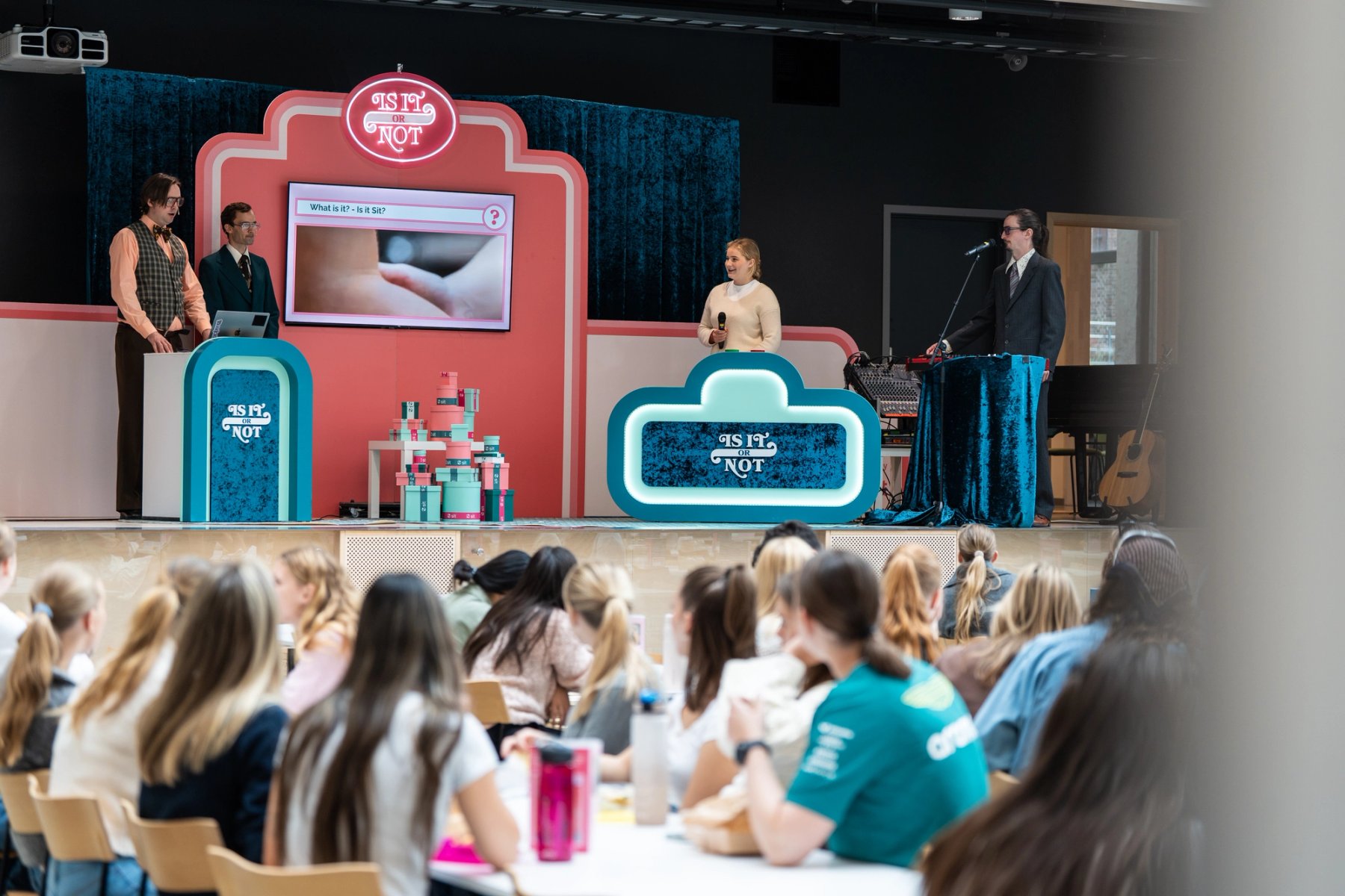 En kvinnelig student står på scenen og svarer på quiz.