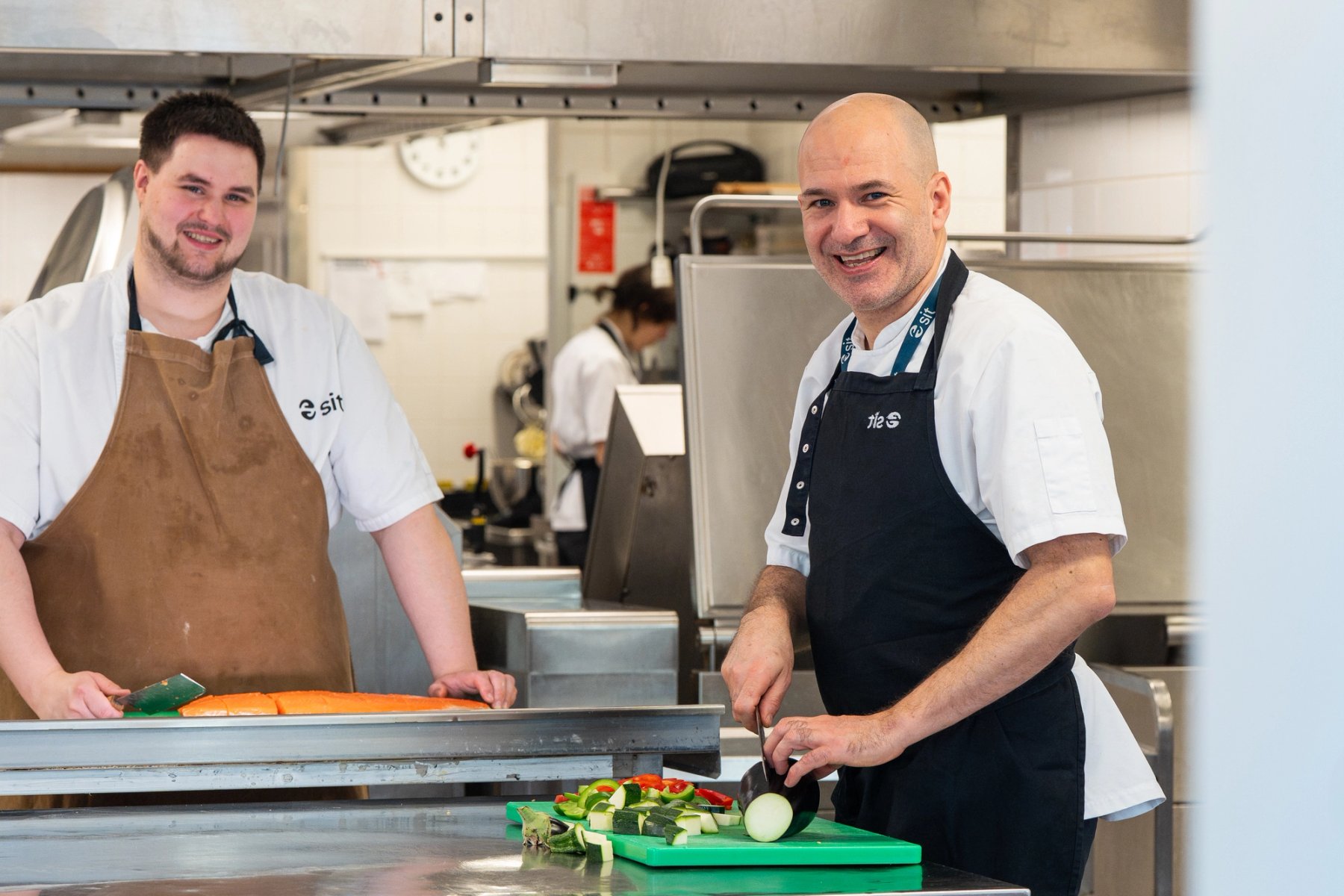 Foto of two chefs smiling and cooking 