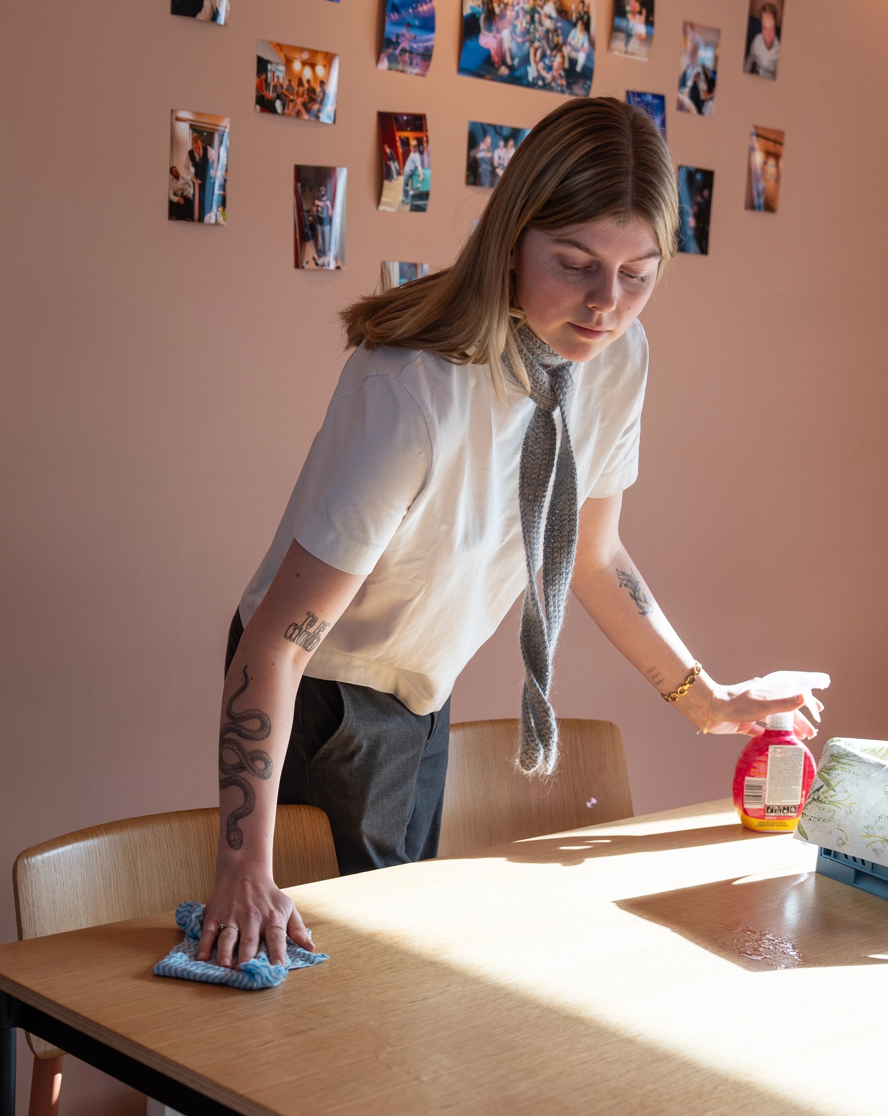 Student cleaning a table in a shared kitchen area in student housing.