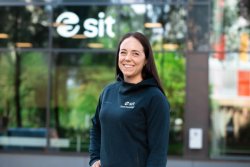 Portrett av Eva Lilleås, senterleder og fysioterapeut i Sit Ålesund. Hun smiler mot kamera og står utendørs foran en Sit-bygning.