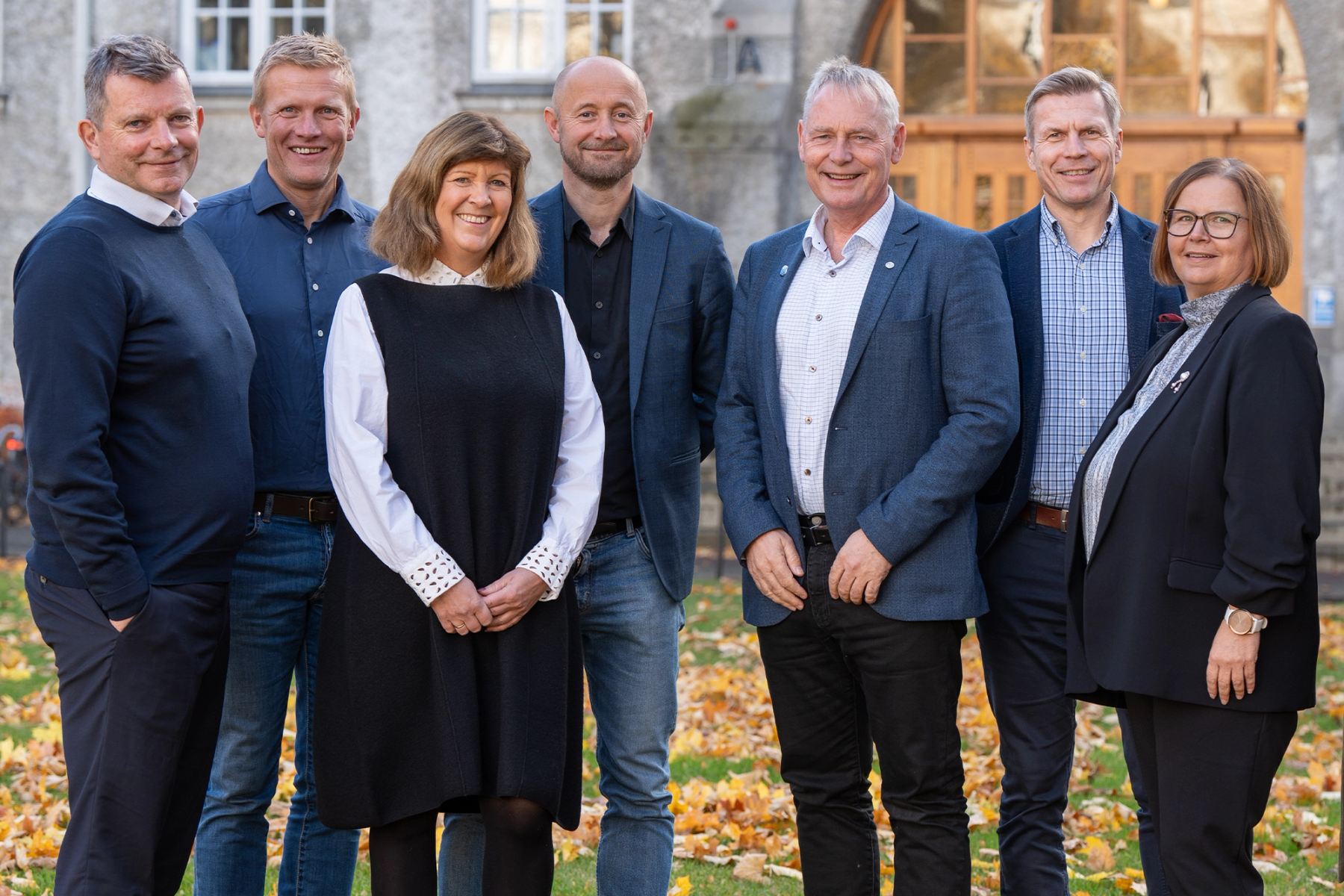 Sit’s management team standing together outdoors in front of a building. From left: Espen Holm, Tor-Arne Hetland, Lisbeth Glørstad Aspås, Gustav Østerberg Øverli, Morten Wolden, Sveinung Hovde, and Heidi Torstad.