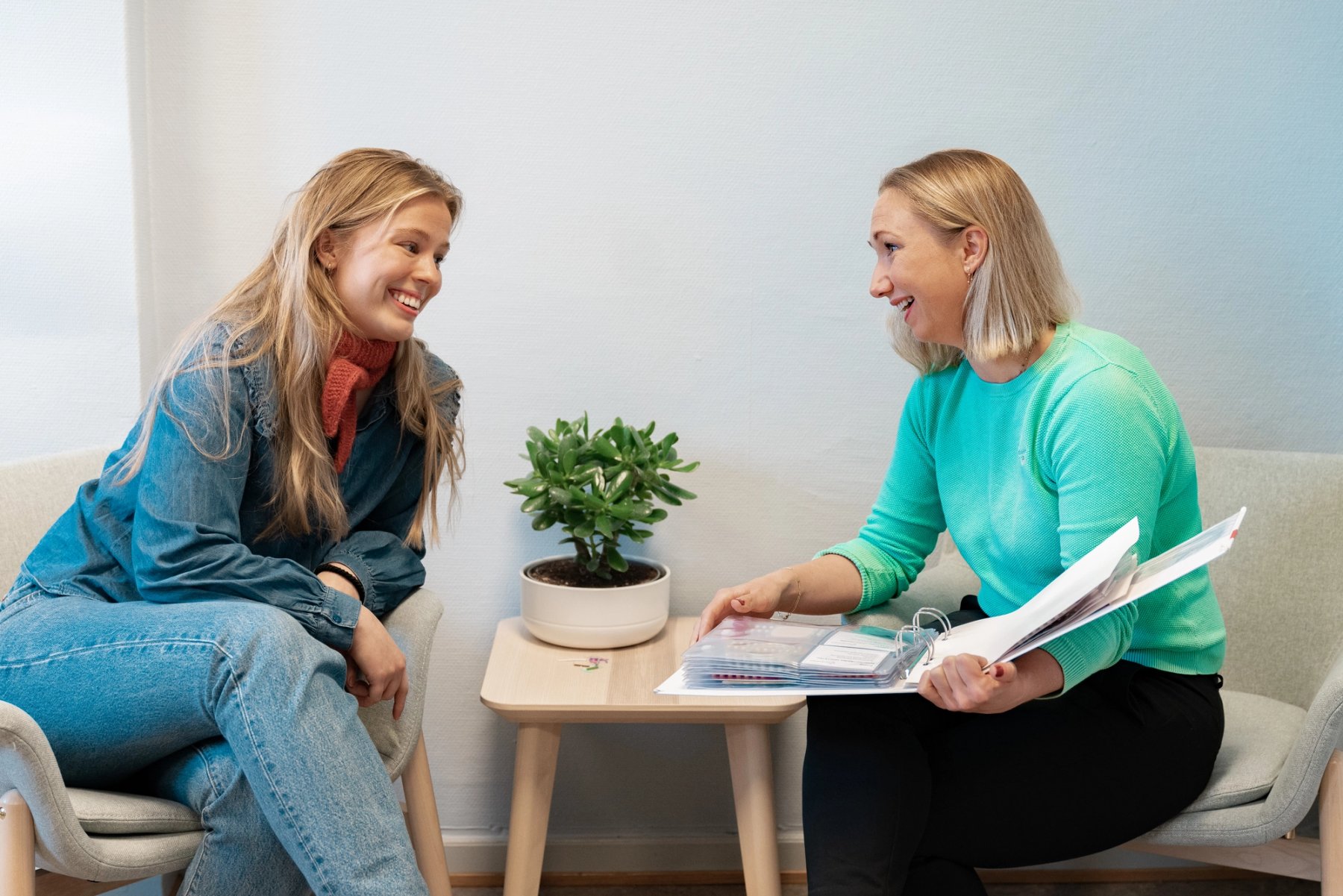 Image of a female student and a public health nurse having a pleasant conversation in an office at Sit.