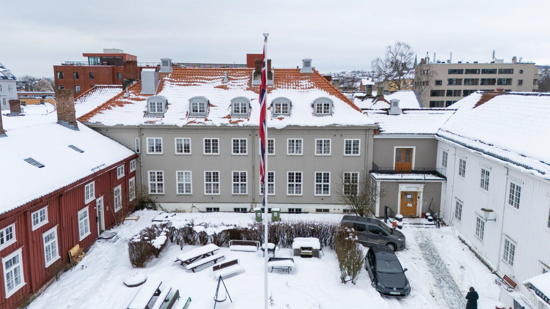 Den trivelige bakgården er opparbeidet med bord og benker, samt flaggstang.