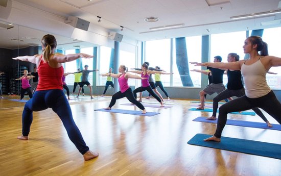 Mennesker som står i en krigerposisjon på yogamatter.