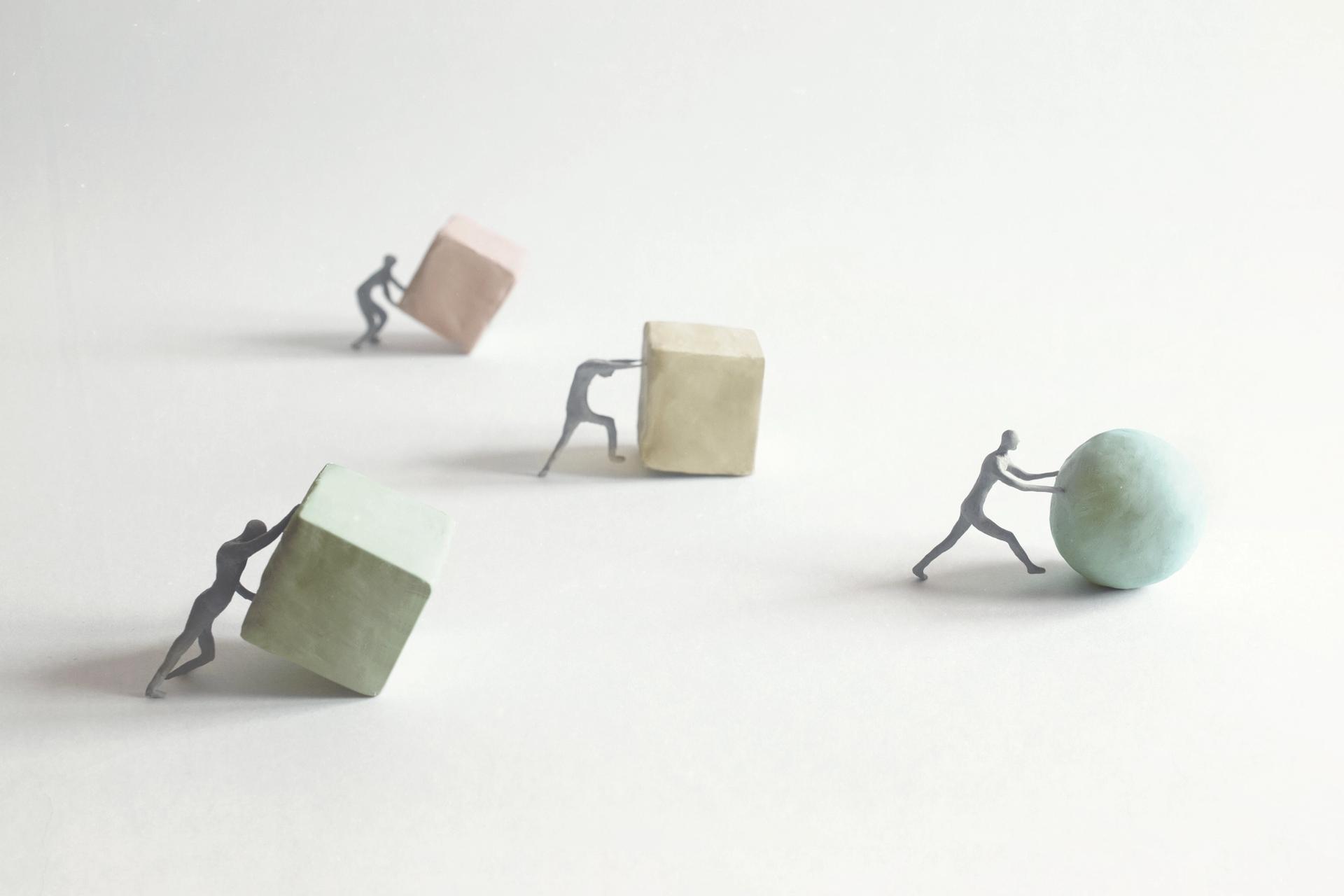 Figures pushing cubes and one figure pushing a ball