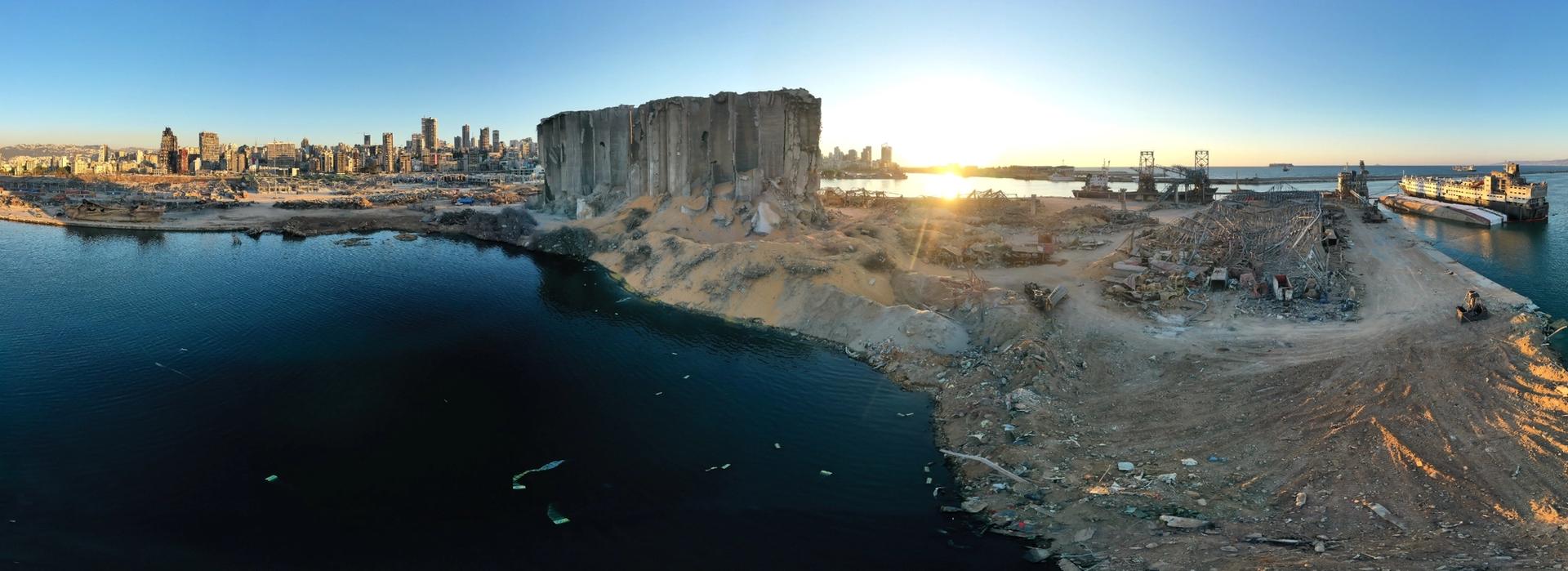 Photograph of the clear-up operation following the Beirut port explosion, showing destroyed buildings and piles of detritus.