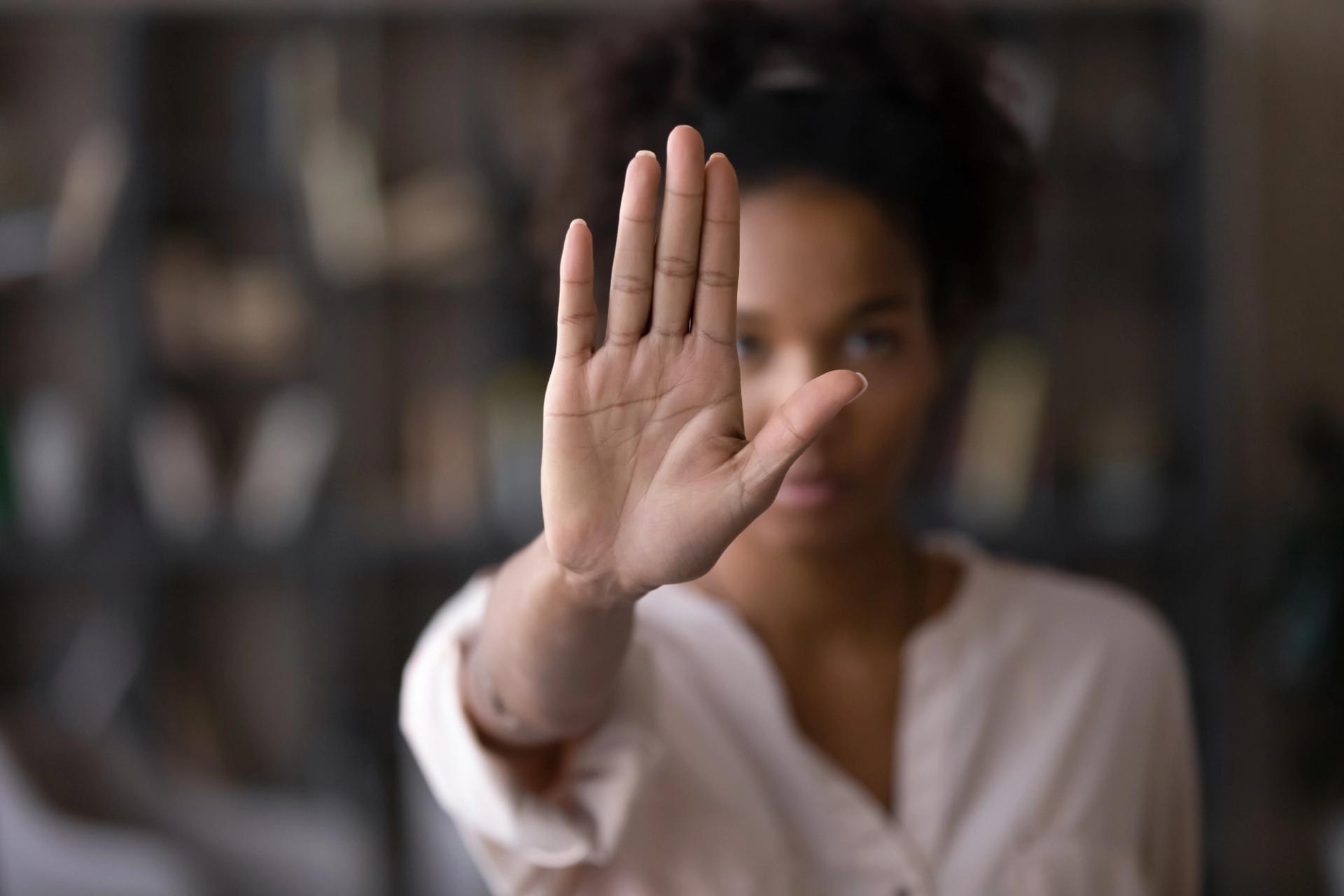 A woman holding up her hand to signal "stop"