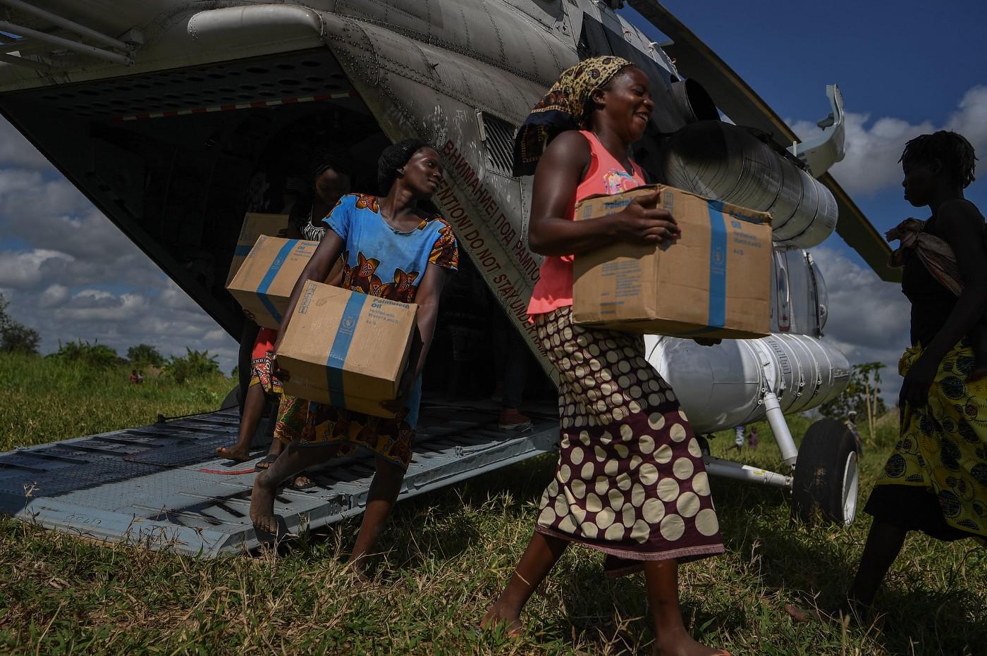 Women in Mozambique offloading boxes from a helicopter