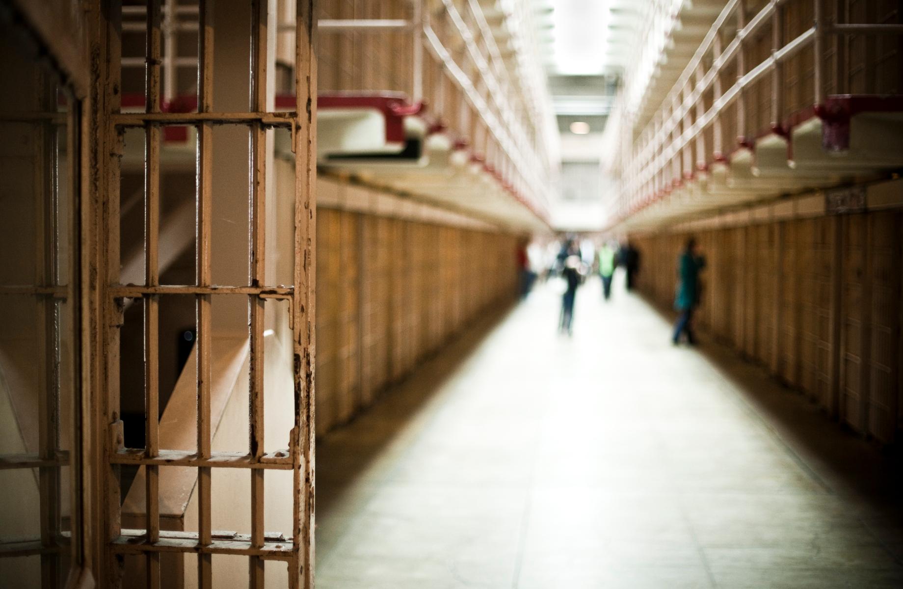A blurry view of a prison corridor with people standing.