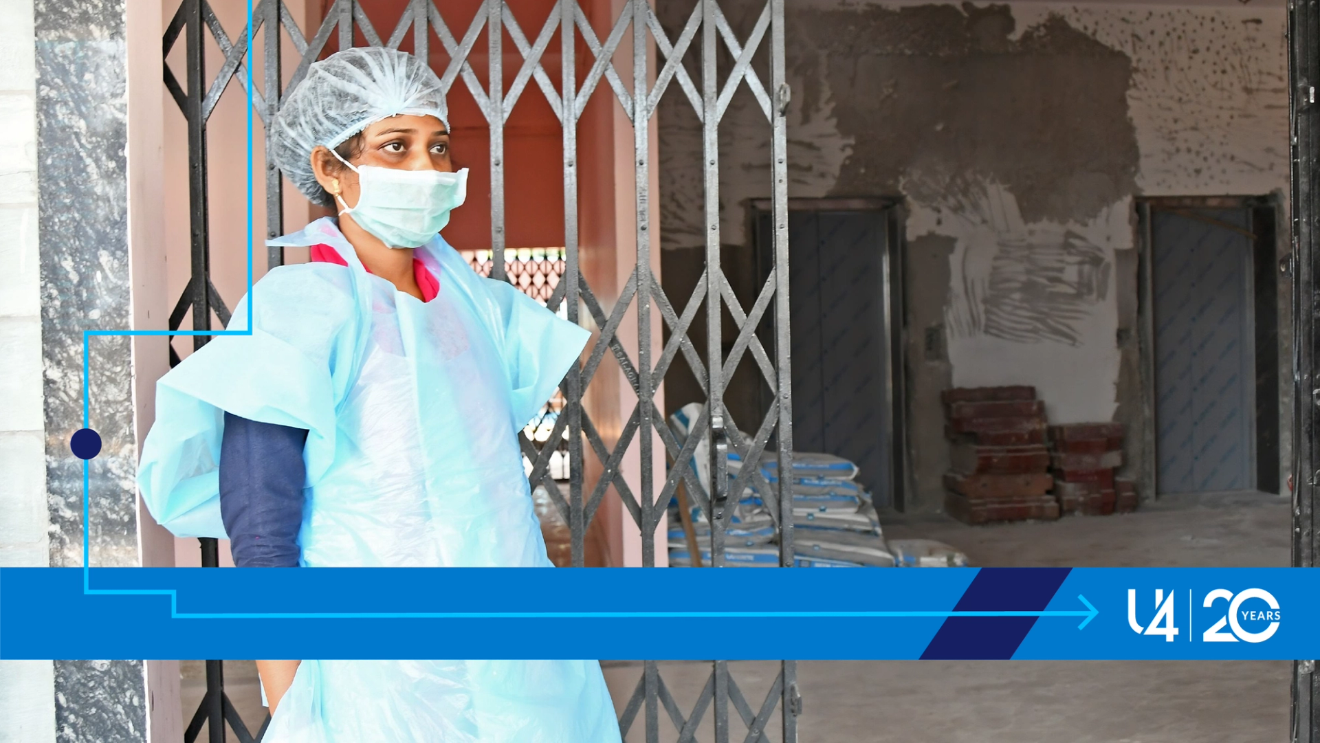 A lady in personal protective gear standing outside a makeshift Covid emergency quarantine centre in India