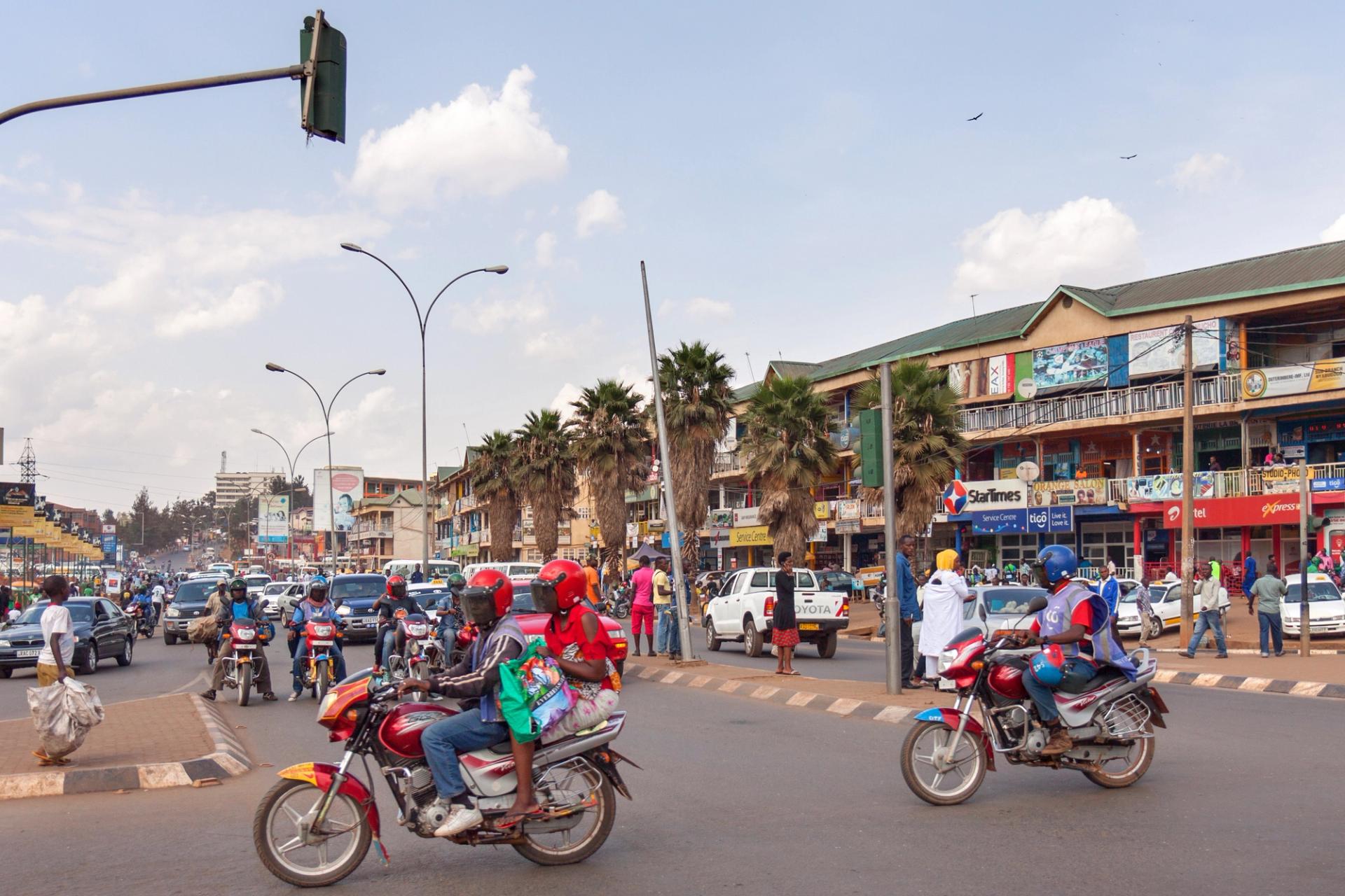 Two motorcycles cross a busy intersection in Kigali, Rwanda
