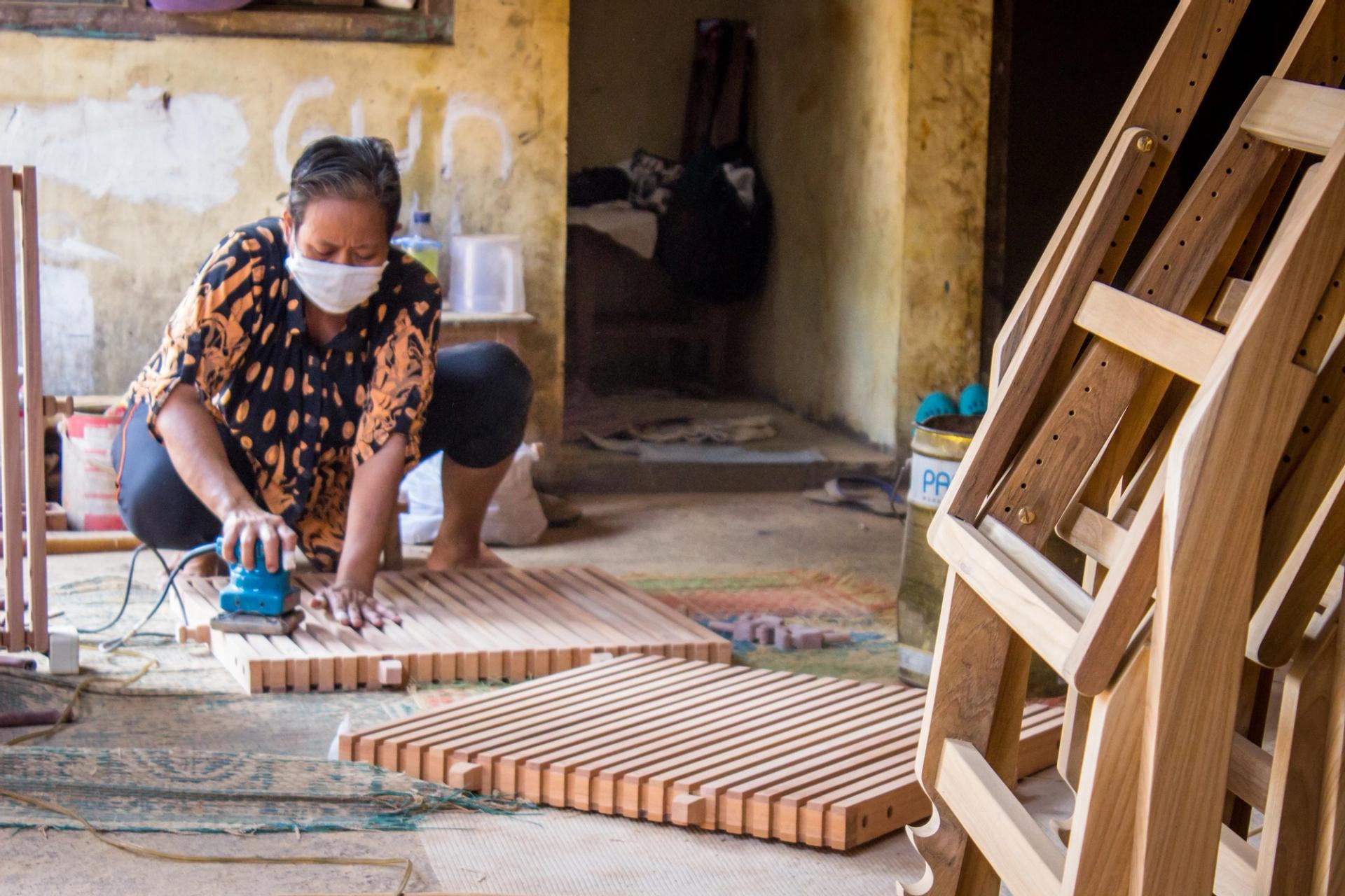 A woman sands furniture at a workshop in Jepara, Indonesia.