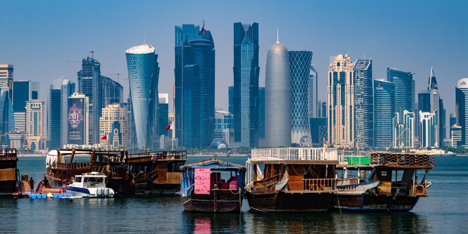 Cityscape of Doha. Traditional boats called a dhow. In the back the skyscrapers of the business district.