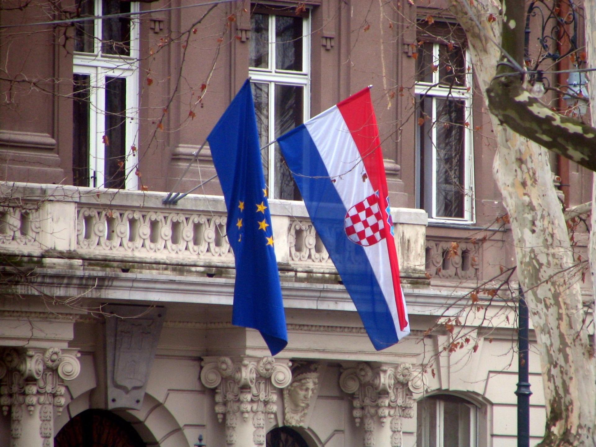 A Croatia flag and EU flag together outside a building