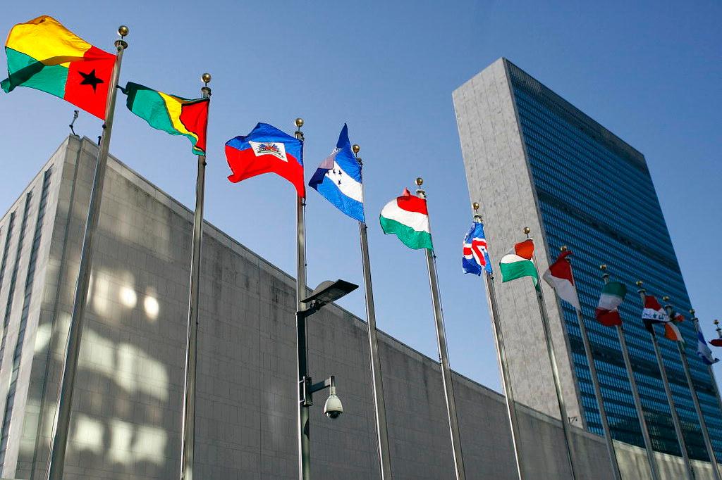 Several national flags flying outside the United Nations building in New York city.