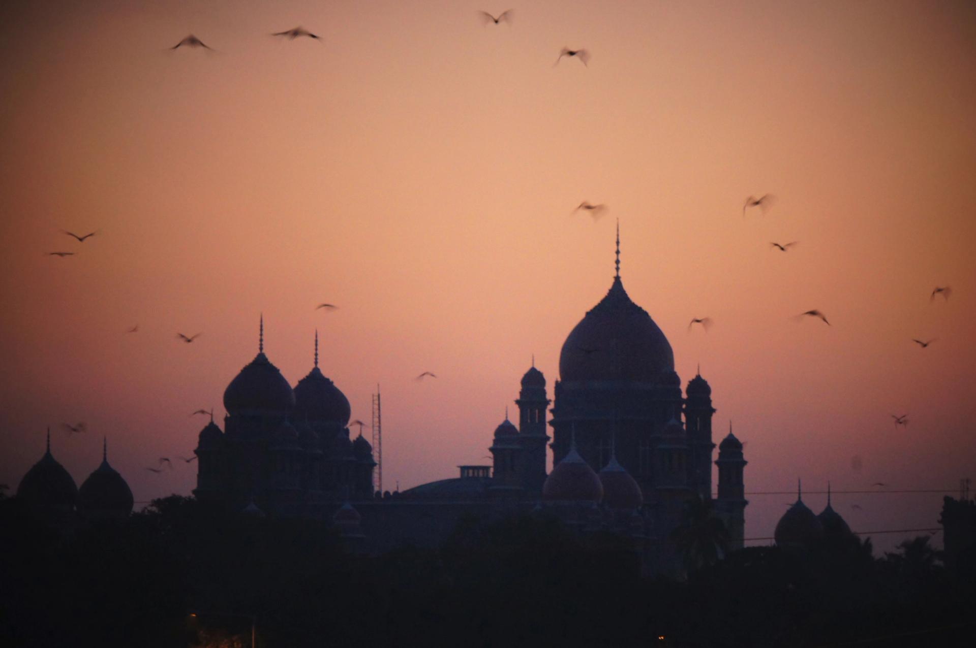 The minarets of Hyderabad High Court, India, in silhouette at dusk. 