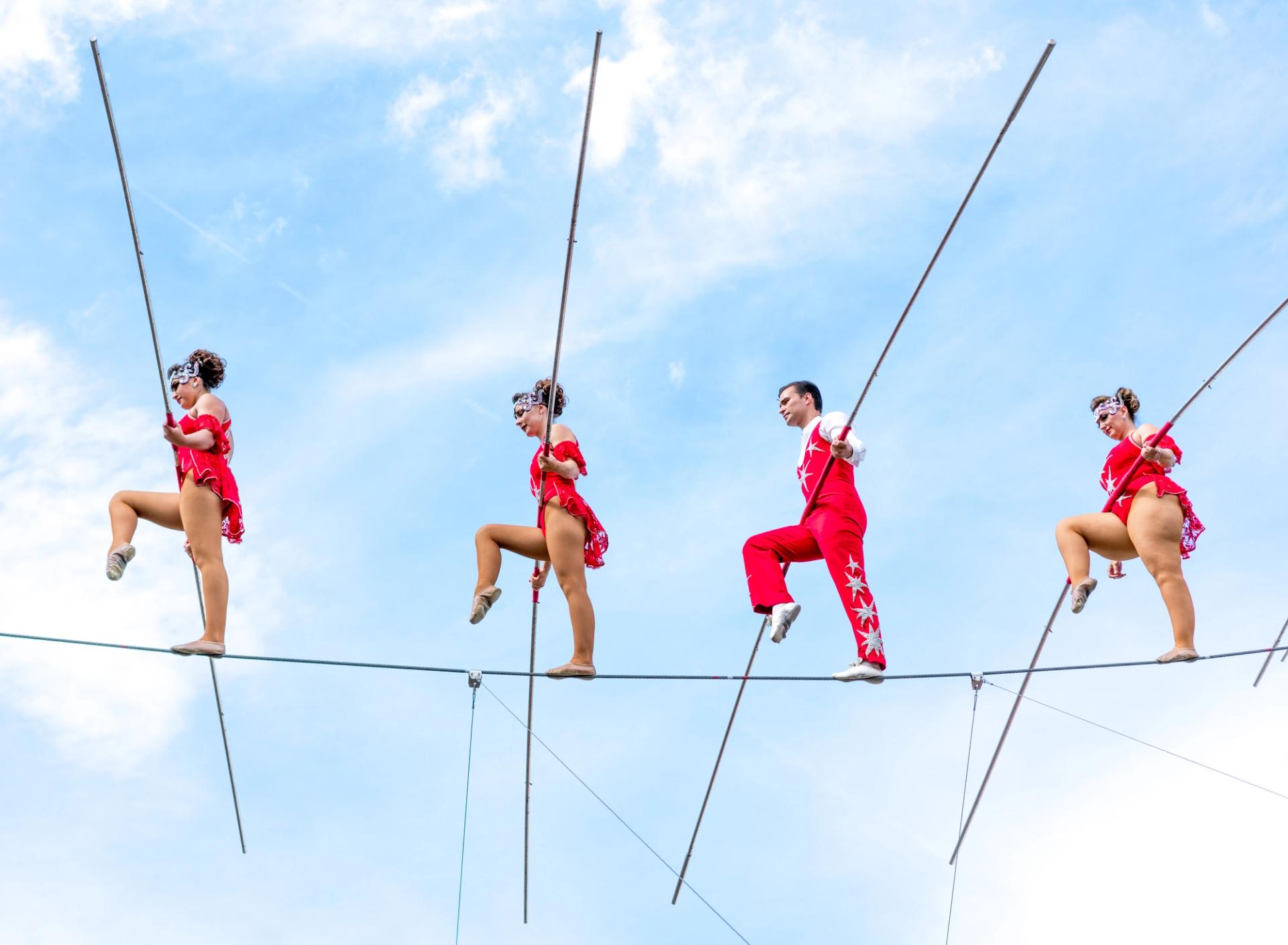 Four artists balancing on a tight-rope