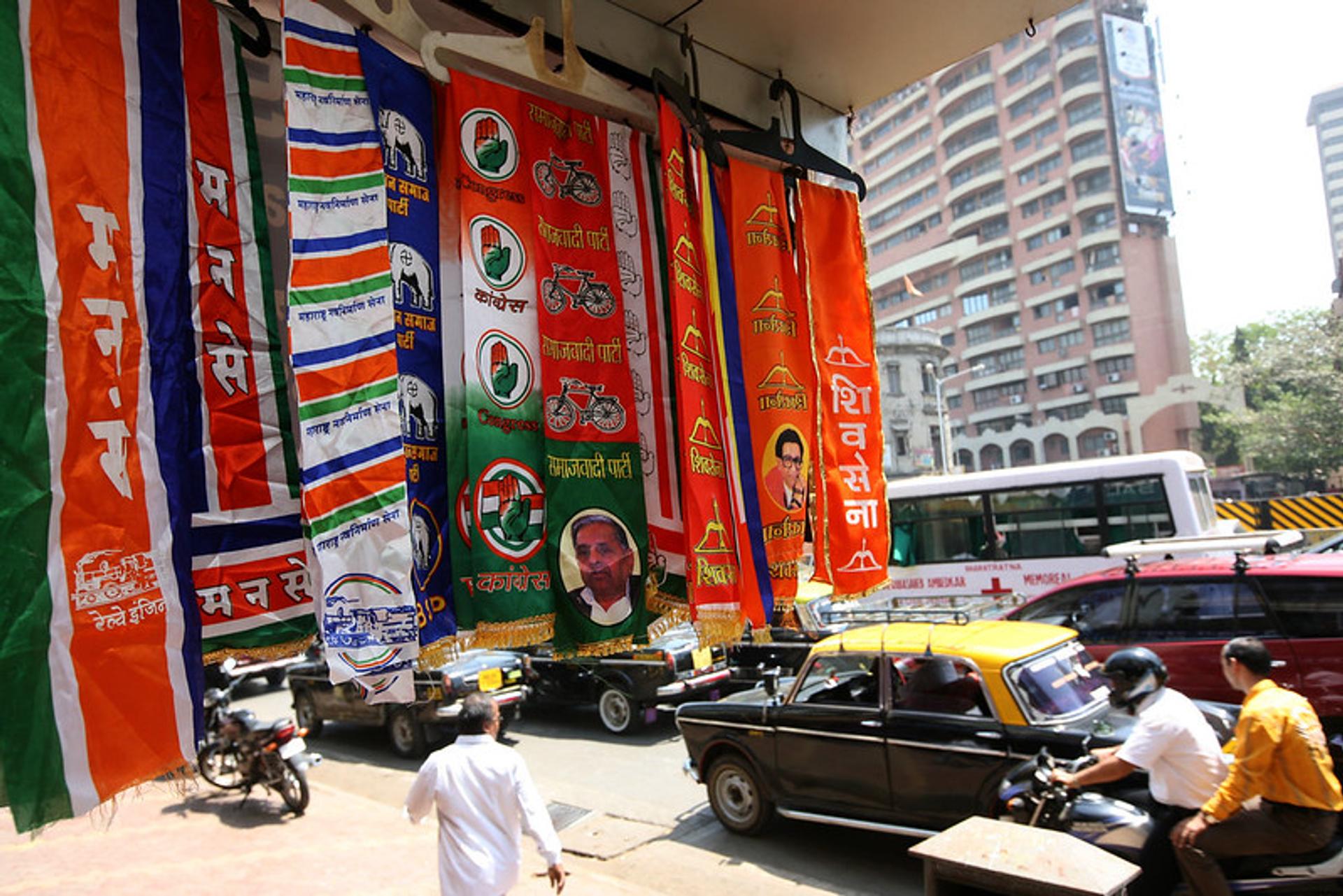 Photograph of brightly coloured scarves or ‘stoles’ of various Indian political parties on display in a shop in the city of Mumbai.