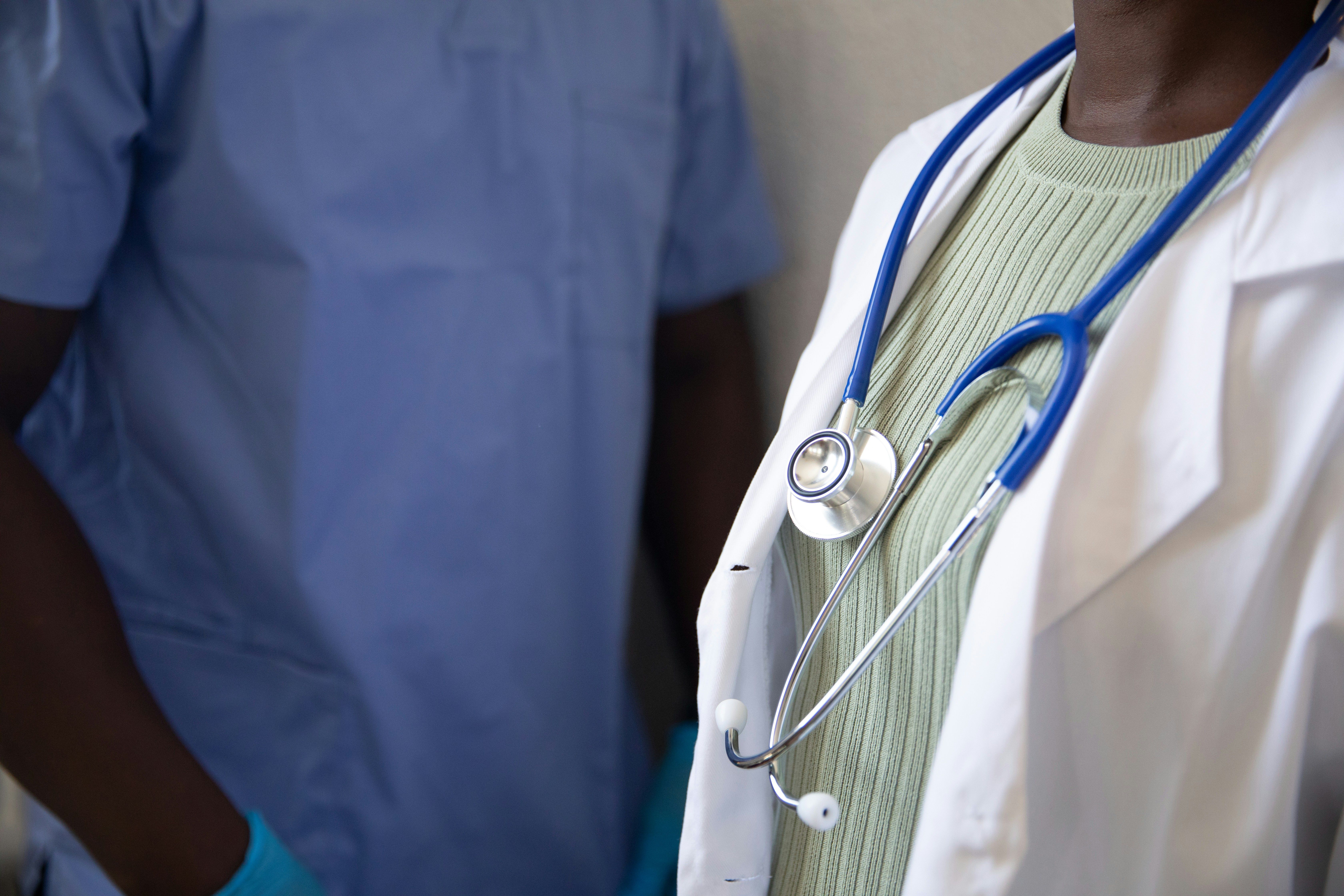 Doctor wearing stethoscope and his assistant