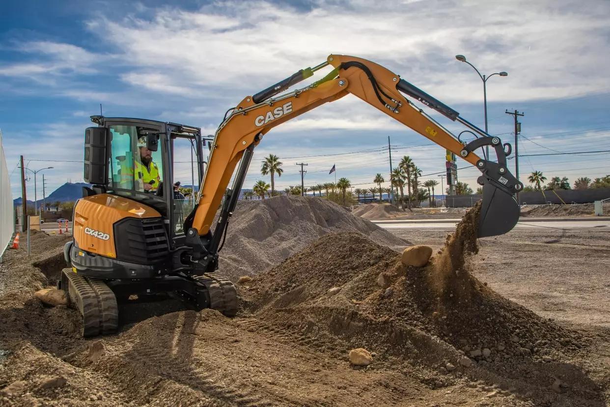 Construction team operating financed compact excavator