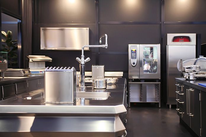Staff setting up newly financed restaurant kitchen equipment