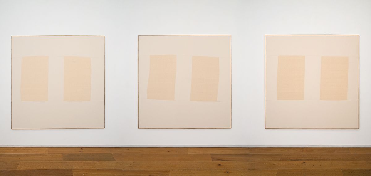 Two minimalist beige paintings with two vertical fabric panels each, on a white wall above a wooden floor.