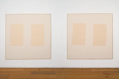 Two minimalist beige paintings with two vertical fabric panels each, on a white wall above a wooden floor.