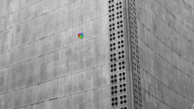 Monochromatic building facade with a small, colorful circular graphic.