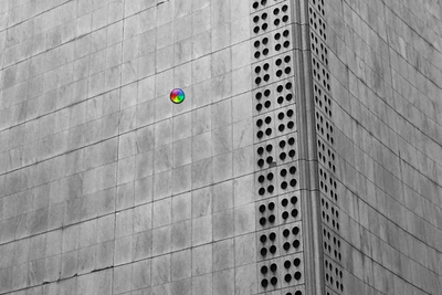Monochromatic building facade with a small, colorful circular graphic.