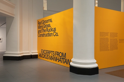 Yellow wall with blue text: "Red Grooms, Mimi Gross, and The Ruckus Construction Co. EXCERPTS FROM RUCKUS MANHATTAN"