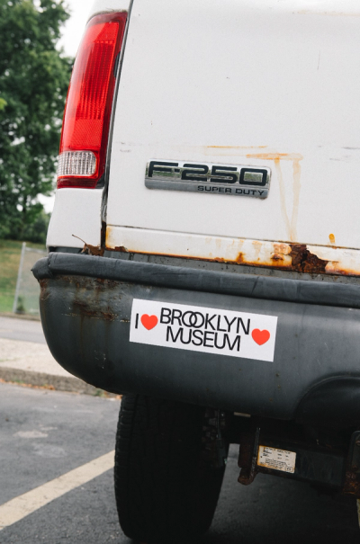 Rear of rusty F-250 pickup has an "I Love Brooklyn Museum" bumper sticker.