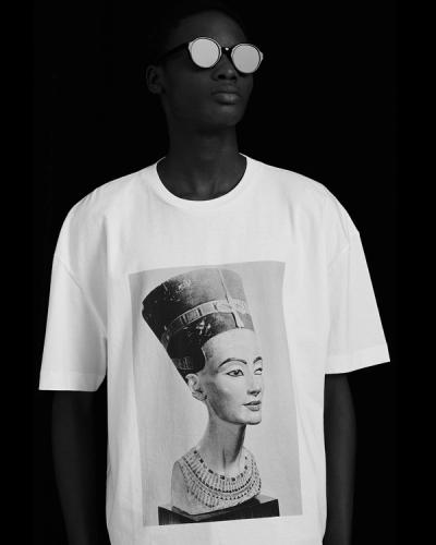 Black and white portrait of a person wearing sunglasses and a t-shirt with Nefertiti bust graphic.
