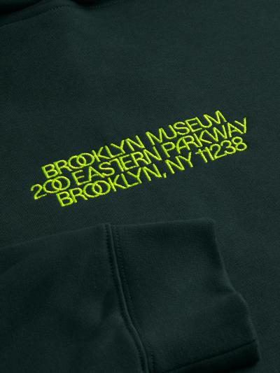 Dark green hoodie with yellow embroidered text: "Brooklyn Museum" and "200 Eastern Parkway Brooklyn NY 11238".