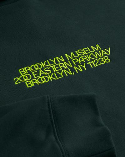 Dark green hoodie with yellow embroidered text: "Brooklyn Museum" and "200 Eastern Parkway Brooklyn NY 11238".