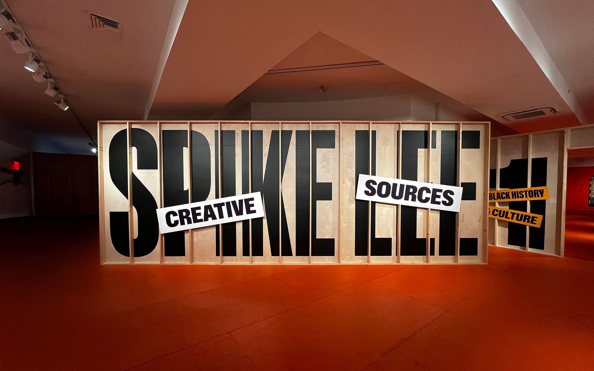 Spike Lee's name in large black letters on wood panels. "Creative Sources" and "Black History Culture" signs.