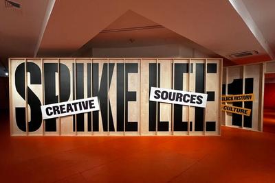 Spike Lee's name in large black letters on wood panels. "Creative Sources" and "Black History Culture" signs.