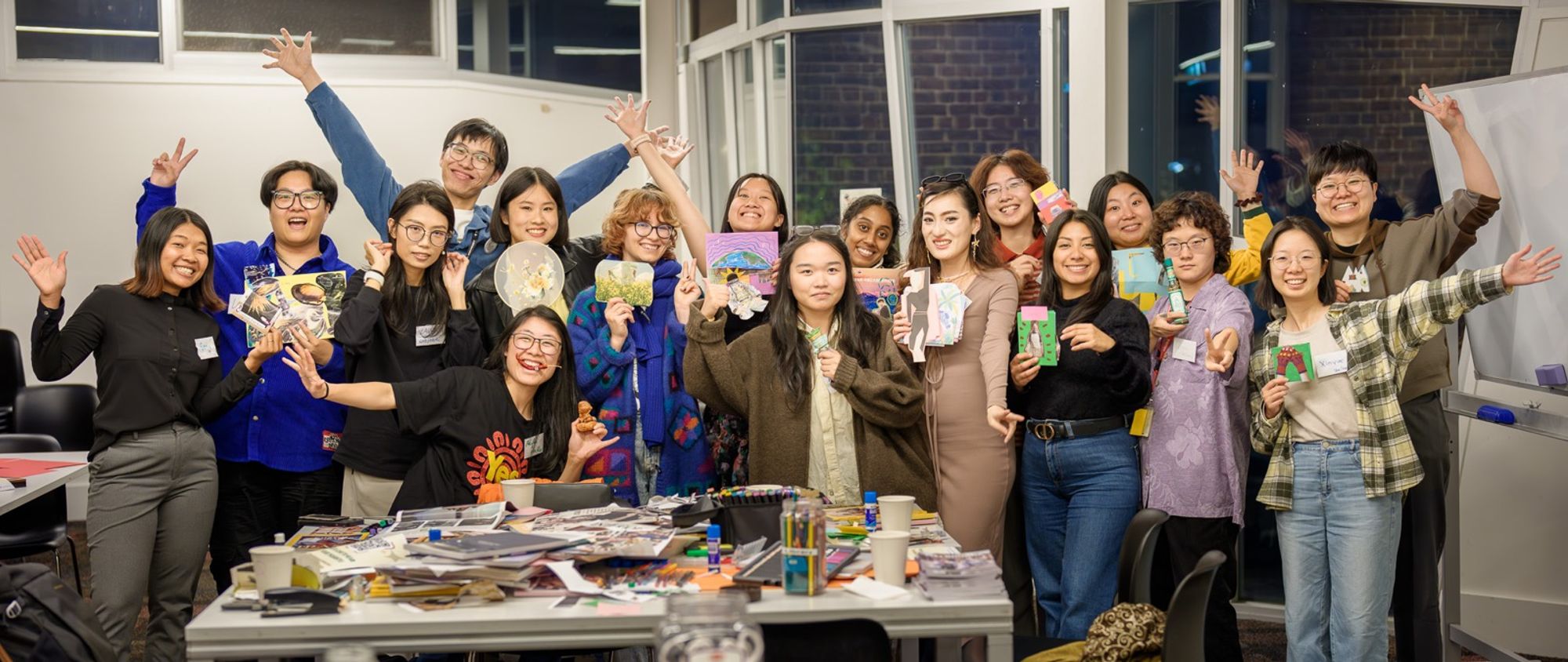 People holding up zines they made at a community workshop