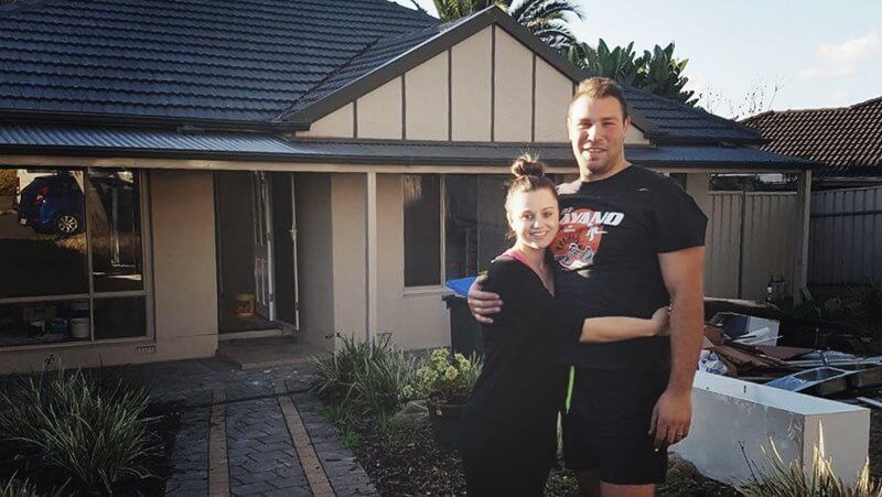 emma and luke couple standing outside their dream home