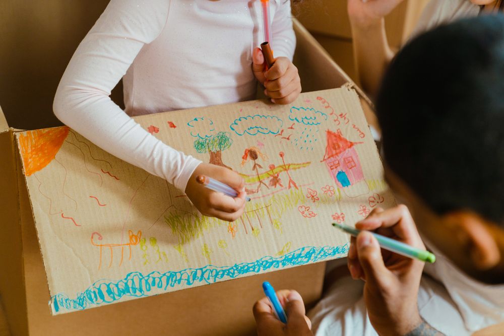 Kids colourful drawing of a family on cardboard box